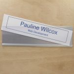 A name plate holder for doors and walls